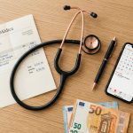 Factura médica privada con estetoscopio y billetes de euro sobre escritorio de madera